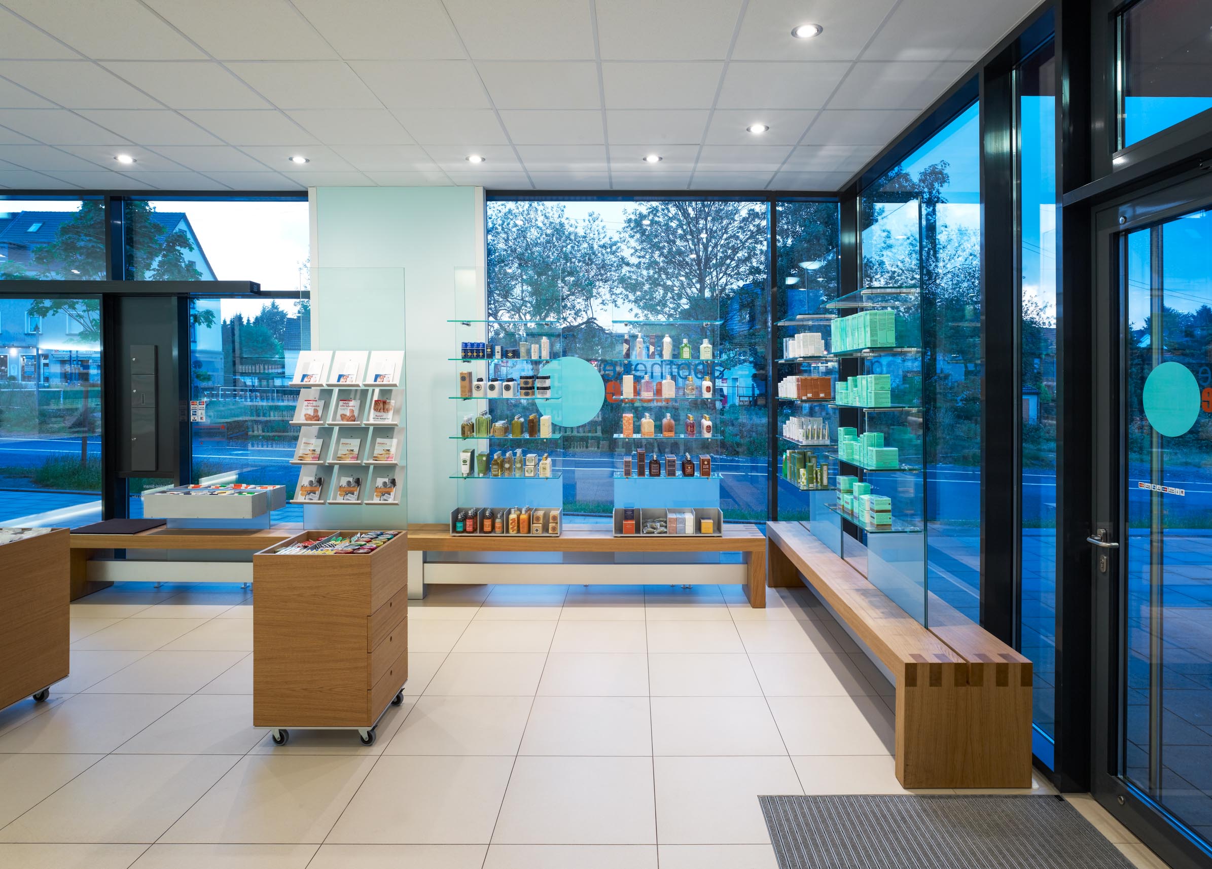 Freiwahl und Sitzbank entlang der großen Schaufensterfront der Apotheke