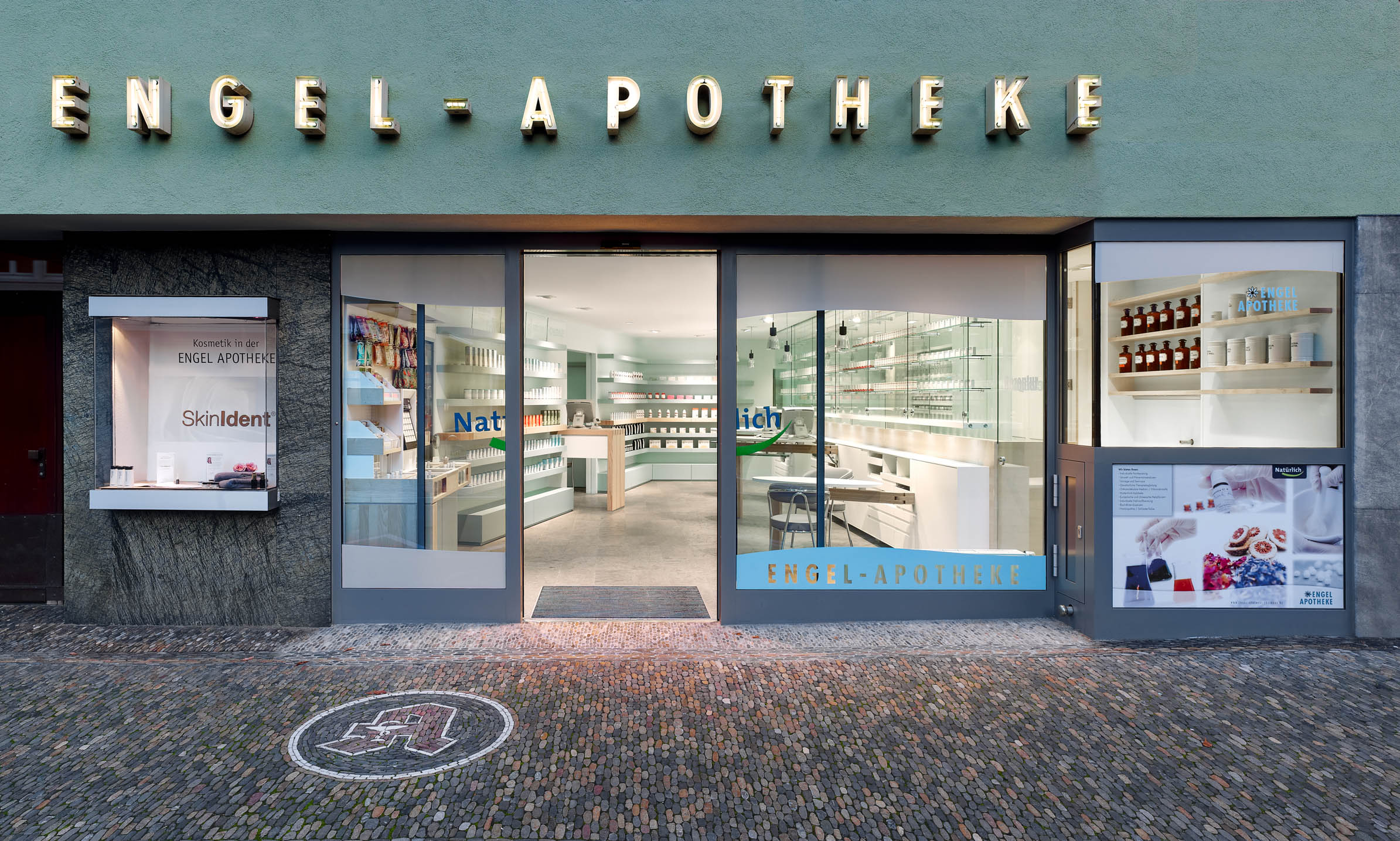 Façade of Engel Pharmacy in Freiburg with a view into the bright dispensary